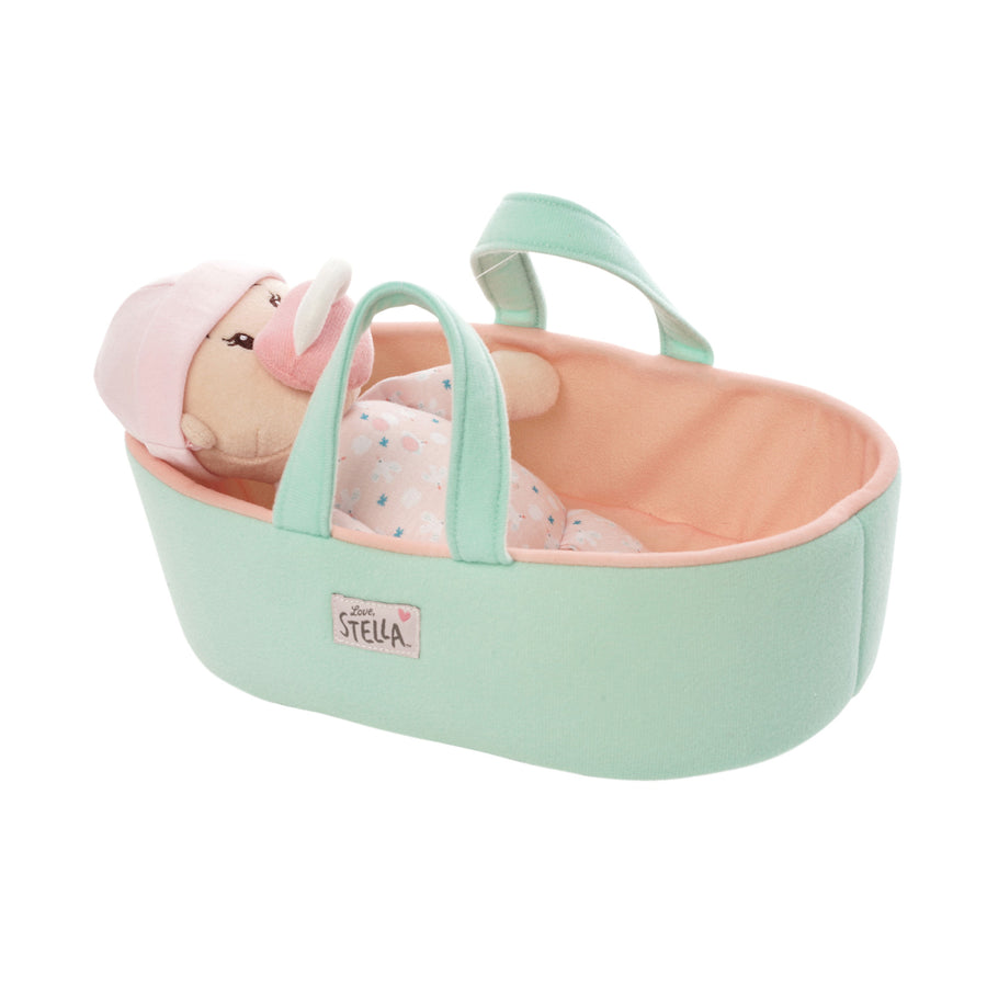 peach skinned soft baby doll with pink beanie and magnetic pacifier on the face laid in a fabric doll sized bassinet