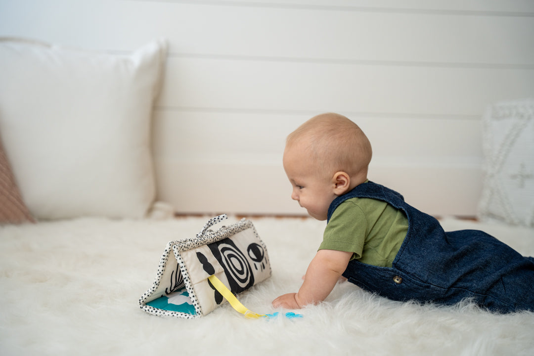 Baby doing tummy time while gazing at a black and white triangle toy